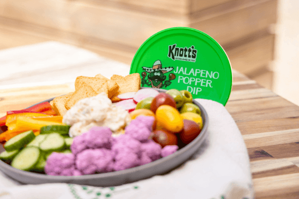 jalapeno popper dip next to plate of veggies