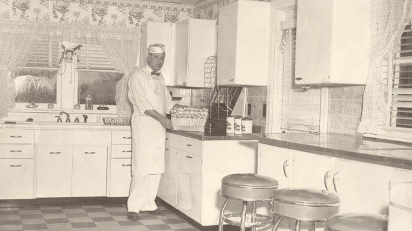 Cedric Knott's standing in kitchen about to pick up a tray of freshly made sandwiches