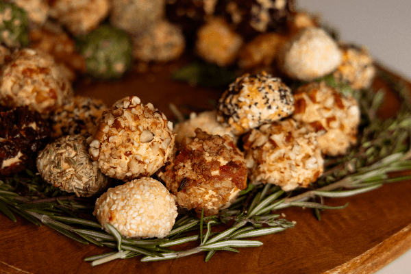 knott yo grandmas cheese balls in a stacked ring on top of rosemary on a wooden board