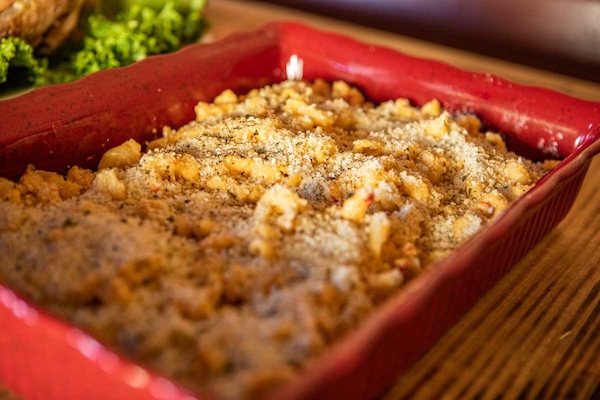 smoked gouda pimiento mac'n' cheese bake in a red casserole dish on a wooden table