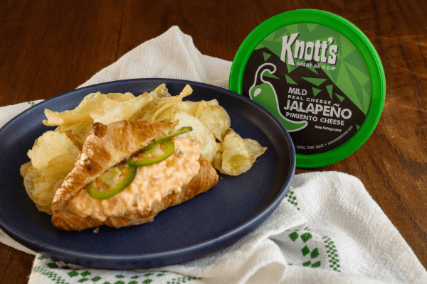 mild jalapeno pimiento cheese next to a sandwich and potato chips