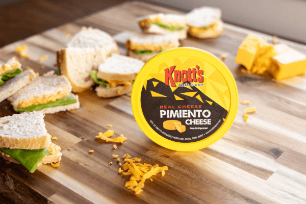 Pimiento cheese on a board surrounded by pimiento cheese sandwiches