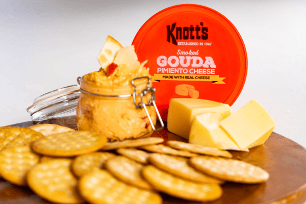 smoked gouda pimiento cheese on a wooden board with crackers and gouda cheese
